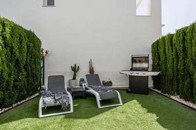 a living room with two chairs and a table and a laptop at CASA LA PLAYA-CONIL Vacaciones de Lujo en Conil con Todas las Comodidades NETFLIX-HBO-DISNEY-CANALES DE FUTBOL-WIFI ALTA VELOCIDAD-SMART TV 65