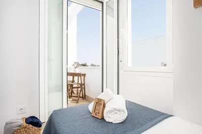 a bedroom with a bed with towels on it at CASA LA PLAYA-CONIL Vacaciones de Lujo en Conil con Todas las Comodidades NETFLIX-HBO-DISNEY-CANALES DE FUTBOL-WIFI ALTA VELOCIDAD-SMART TV 65