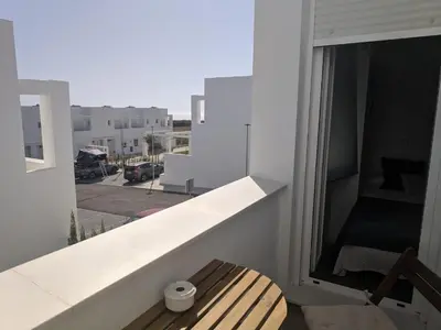 a balcony with a bench and a view of a street at CASA LA PLAYA-CONIL Vacaciones de Lujo en Conil con Todas las Comodidades NETFLIX-HBO-DISNEY-CANALES DE FUTBOL-WIFI ALTA VELOCIDAD-SMART TV 65