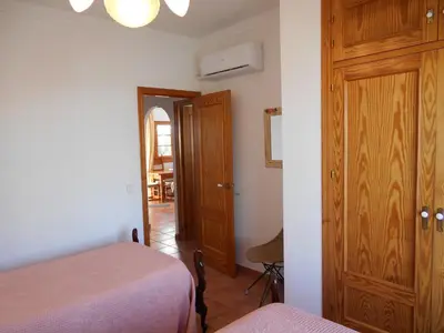 a bedroom with two beds and a wooden door at Penthouse on the Costa de la Luz, Air conditioning, beach 300 meters away in Chipiona