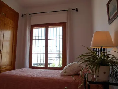a bedroom with a bed with a window and a plant at Penthouse on the Costa de la Luz, Air conditioning, beach 300 meters away in Chipiona