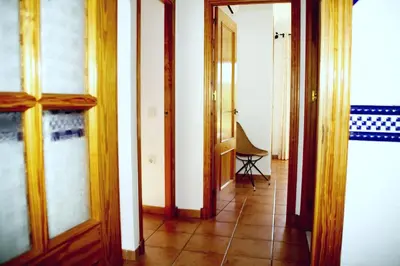 a hallway with wooden doors and a tiled floor at Penthouse on the Costa de la Luz, Air conditioning, beach 300 meters away in Chipiona
