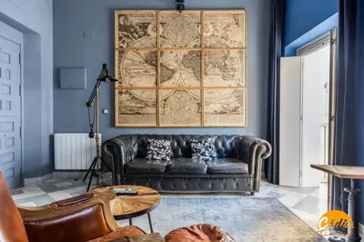 a living room with a leather couch and a map at Blue Home by Cadiz Time in Cádiz