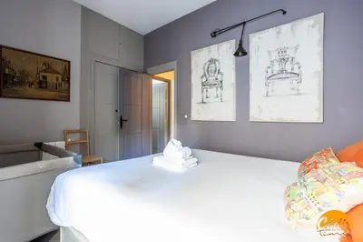 a bedroom with a white bed with drawings on the wall at Blue Home by Cadiz Time in Cádiz
