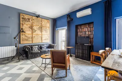a living room with blue walls and a map on the wall at Blue Home by Cadiz Time in Cádiz