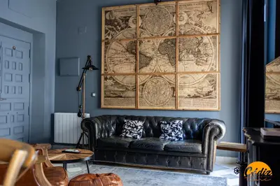a leather couch in a living room with a large map on the wall at Blue Home by Cadiz Time in Cádiz