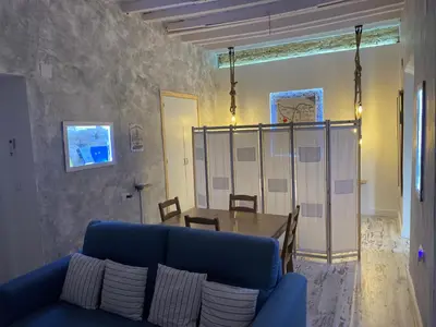 a living room with a blue couch and a table at LA CUEVA DEL LOCO, Bretones 29 in Sanlúcar de Barrameda