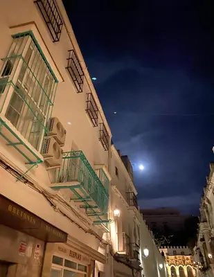 a building with green balconies on the side of it at LA CUEVA DEL LOCO, Bretones 29 in Sanlúcar de Barrameda