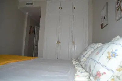 a bedroom with a white bed with two pillows at Céntrico y amplio apartamento 100% equipado in Jerez de la Frontera