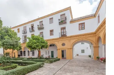 an exterior view of a large white building with a courtyard at Céntrico y amplio apartamento 100% equipado in Jerez de la Frontera