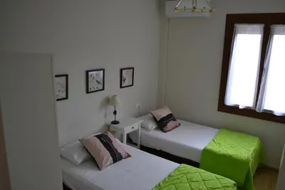 a bedroom with two beds and a window at Céntrico y amplio apartamento 100% equipado in Jerez de la Frontera