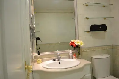 a bathroom with a sink and a toilet and a mirror at Céntrico y amplio apartamento 100% equipado in Jerez de la Frontera