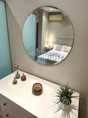 a bedroom with a mirror and a bed in a room at GATU Herrería in El Puerto de Santa María