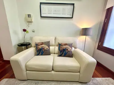 a white couch with two pillows on it in a living room at GATU Herrería in El Puerto de Santa María