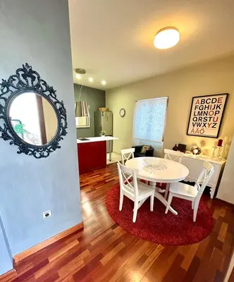 a living room with a table and chairs and a kitchen at GATU Herrería in El Puerto de Santa María