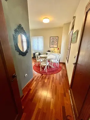 a dining room with a table and chairs and a table and a mirror at GATU Herrería in El Puerto de Santa María