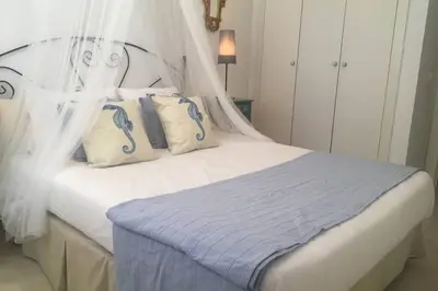 a bedroom with a white bed with a canopy at GATU PREMIUM El Puerto Centro aire acc, calefacc, wifi, parking y piscina comun Preferente mayores de 25 años y familias 