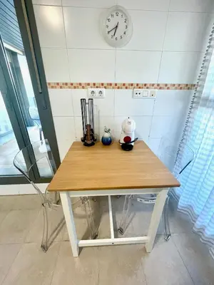 a table in a room with a clock on the wall at GATU PREMIUM El Puerto Centro aire acc, calefacc, wifi, parking y piscina comun Preferente mayores de 25 años y familias 