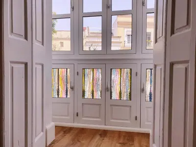 a room with four doors with windows at Sherryflat Plateros in Jerez de la Frontera