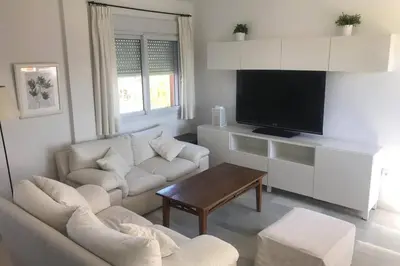 a living room with a couch and a tv at Precioso apartamento muy cerca de la playa in Chiclana de la Frontera