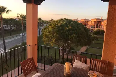 a table on a balcony with a view of a street at Precioso apartamento muy cerca de la playa in Chiclana de la Frontera