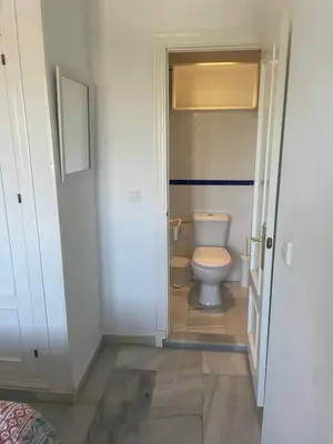a bathroom with a toilet and a door open at Precioso apartamento muy cerca de la playa in Chiclana de la Frontera