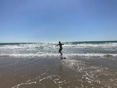 a person walking in the water on the beach at Precioso apartamento muy cerca de la playa in Chiclana de la Frontera