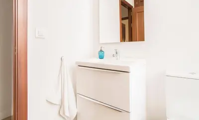 a white bathroom with a sink and a mirror at APARTOYOU PREMIUM - Apartamentos Casa Linares in El Puerto de Santa María