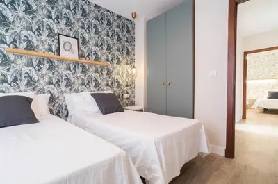two beds in a room with a wall mural at APARTOYOU PREMIUM - Apartamentos Casa Linares in El Puerto de Santa María
