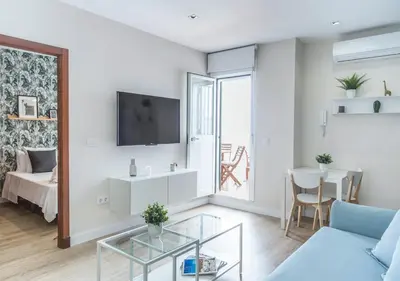 a living room with a couch and a tv on a wall at APARTOYOU PREMIUM - Apartamentos Casa Linares in El Puerto de Santa María