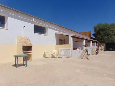 a house with a table and chairs in front of it at Finca La Parrilla in Arcos de la Frontera