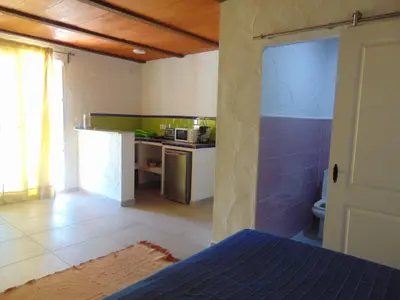 a room with a kitchen and a room with a bed at Finca La Parrilla in Arcos de la Frontera