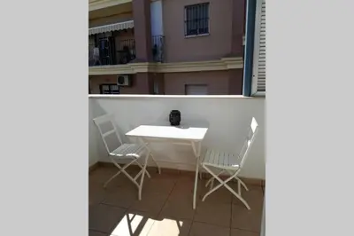 a white table and chairs on a balcony at Atico La Estacion in Sanlúcar de Barrameda
