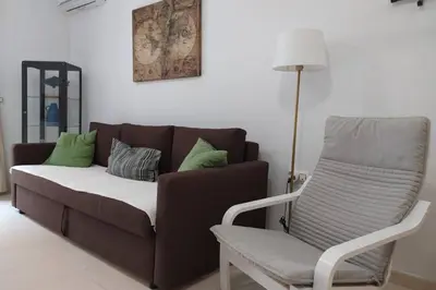 a couch and a chair in a living room at Atico La Estacion in Sanlúcar de Barrameda