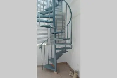 a blue spiral staircase in the corner of a room at Atico La Estacion in Sanlúcar de Barrameda