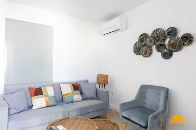 a living room with a blue couch and a chair at Apartamento Oceano by Cadiz Time in Cádiz