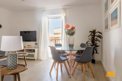 a dining room with a table with chairs and a vase of flowers at Apartamento Oceano by Cadiz Time in Cádiz