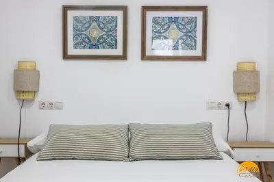 a bedroom with two pictures on the wall and a bed at Apartamento Oceano by Cadiz Time in Cádiz