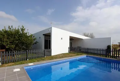 a white house with a swimming pool in front of it at VILLA ELLY in Conil de la Frontera