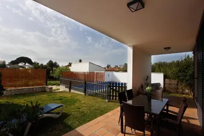 a patio with a table and chairs in a yard at VILLA ELLY in Conil de la Frontera