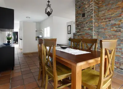 a kitchen and dining room with a wooden table and chairs at VILLA ELLY in Conil de la Frontera
