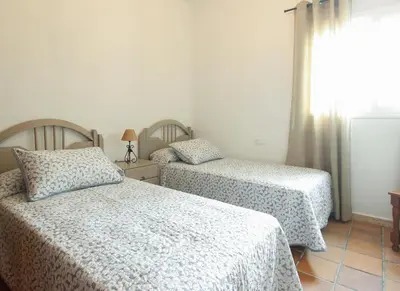 a bedroom with two beds and a window at VILLA ELLY in Conil de la Frontera