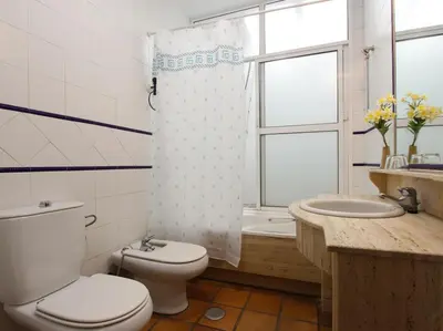 a bathroom with a toilet and a sink and a shower at VILLA ELLY in Conil de la Frontera