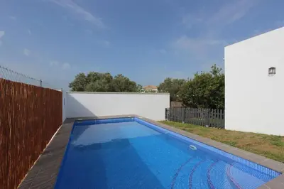 a swimming pool in a backyard with a fence at VILLA ELLY in Conil de la Frontera
