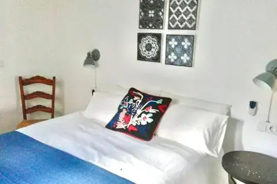 a bedroom with a white bed with two pillows on it at La Puerta Azul in Bornos