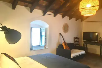 a bedroom with a bed and a chair and a window at La Puerta Azul in Bornos