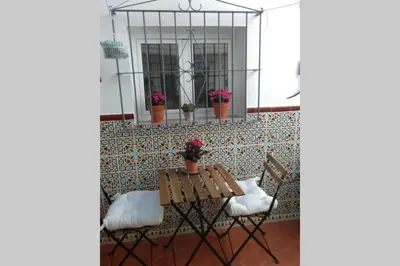 a table and chairs with flowers on a wall at La Puerta Azul in Bornos