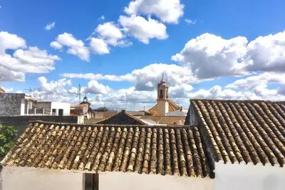 a roof of a building with a church in the background at La Puerta Azul in Bornos