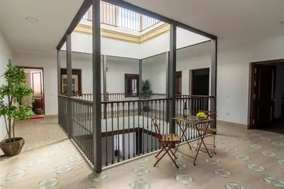 a large room with a table and a mirror at Apartamentos Turísticos Mamelón in Jerez de la Frontera