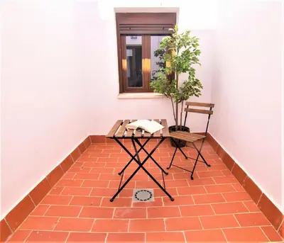 a table and a chair on a brick floor at Apartamentos Turísticos Mamelón in Jerez de la Frontera